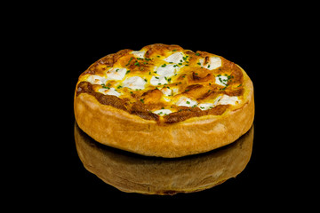 quiche with pumpkin and cheese on black glass with reflection