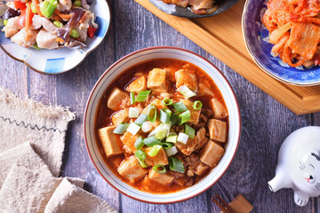 A bowl of rice with mapo doufu on a table                                                    