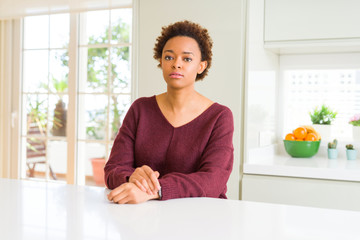Young beautiful african american woman at home Relaxed with serious expression on face. Simple and natural looking at the camera.