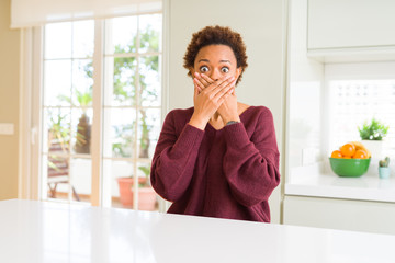 Young beautiful african american woman at home shocked covering mouth with hands for mistake. Secret concept.