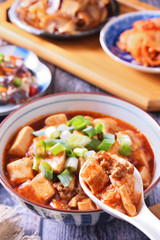 A bowl of rice with mapo doufu on a table                                                    