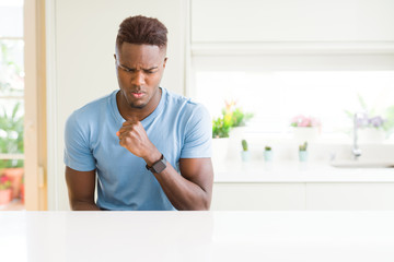 Handsome african american man wearing casual t-shirt at home feeling unwell and coughing as symptom for cold or bronchitis. Healthcare concept.