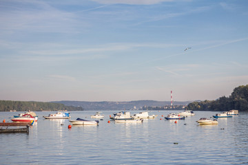 Fototapeta na wymiar Zemun Quay (Zemunski Kej) in Belgrade, Serbia, on the Danube river, seen in autumn, during the afternoon. Boats can be seen in front, and Belgrade center in background
