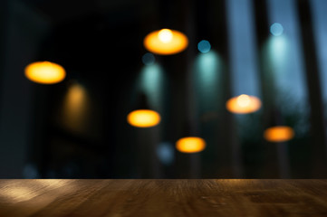 blur orange lamp in the dark night bar or pub with wood top background