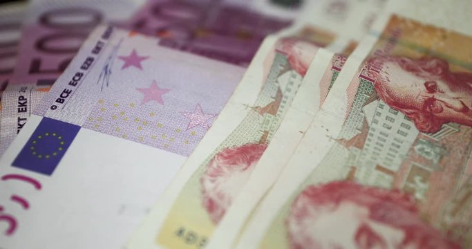 Slow Motion Shot Rotating From 500 Euros Notes To 50 Great Britain Pounds Notes Laid Down Over A Table - &euro;500 To &pound;50 GBP Bills - 4K 30fps