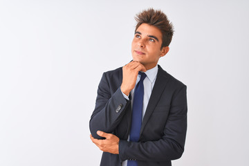 Young handsome businessman wearing suit standing over isolated white background with hand on chin thinking about question, pensive expression. Smiling with thoughtful face. Doubt concept.