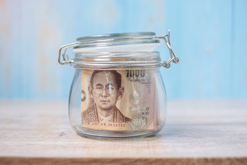 1000 Thai Baht banknote in glass jar. Money, business, investment, retirement planning, finance and world Saving day concepts