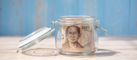 1000 Thai Baht banknote in glass jar. Money, business, investment, retirement planning, finance and world Saving day concepts