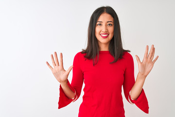 Young beautiful chinese woman wearing red dress standing over isolated white background showing and pointing up with fingers number ten while smiling confident and happy.