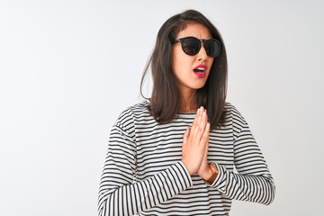 Chinese woman wearing striped t-shirt and sunglasses standing over isolated white background...