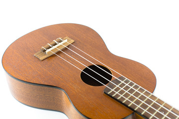 Fototapeta premium Close-up head of dark wooden ukulele music instrument Hawaiian guitar body with selected focus and copy space isolated over white background.