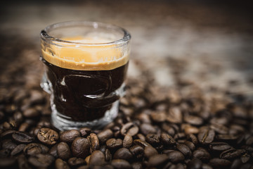 skull glass of coffee espresso shot with beans on brown wooden background 