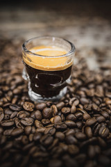 skull glass of coffee espresso shot with beans on brown wooden background 