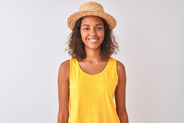 Young brazilian woman wearing yellow t-shirt and summer hat over isolated white background with a happy and cool smile on face. Lucky person.