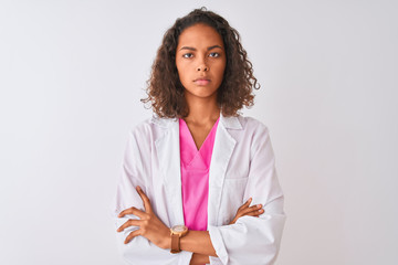 Young brazilian doctor woman wearing coat standing over isolated white background skeptic and...