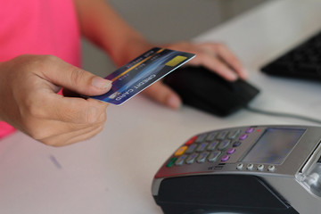 closeup of hand with credit card and pen