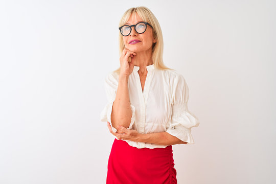 Middle age businesswoman wearing shirt and glasses standing over isolated white background with hand on chin thinking about question, pensive expression. Smiling with thoughtful face. Doubt concept.