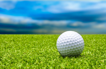Golf ball on tee with blue sky