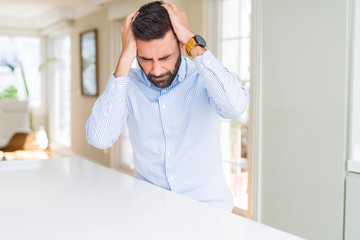 Handsome hispanic business man suffering from headache desperate and stressed because pain and...