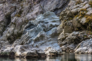 Striking gray rocks look like a lion sitting on the side of the Yoshino river in Japan