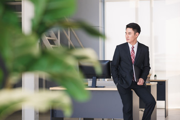 Businessman holding notebook computer in office..