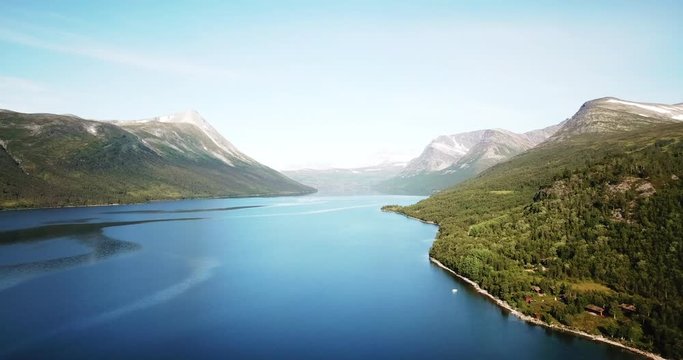 Gjevilvatnet is a beautiful lake in Norway. It is a popular tourist destination both during winter and summer. Aerial footage at high altitude. Left to right pan facing west.