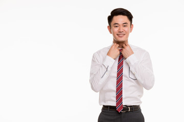 Young Asian businessman is manage his shirt..
