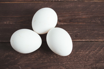 White chicken eggs and shell on a dark wooden background.