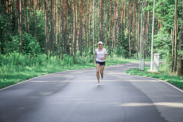 Beautiful young girl walks in a pine forest