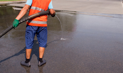 Employees of the municipality washes the street with water pressure from the car.
