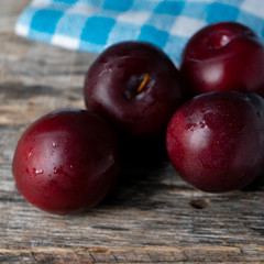 Juicy plums on wooden background