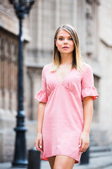 Young serious female standing in the historical city center of Barcelona