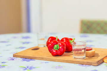 Three red peppers on a table in a country house after harvest