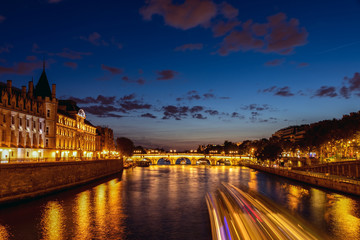Fototapeta na wymiar Illuminated Conciergerie and Pont Neuf bridge at night - Paris, France.