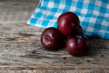 Juicy plums on wooden background