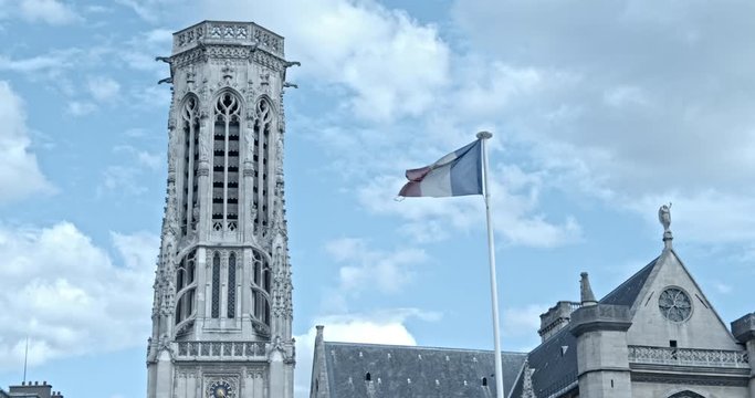 Flag of France on a Flag Pole waving in front of Saint-Germain-l'Auxerrois near the Louvre