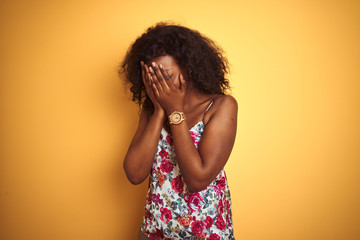 African american woman wearing floral summer t-shirt over isolated yellow background with sad...