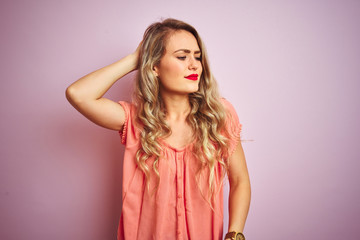 Young beautiful woman wearing t-shirt standing over pink isolated background confuse and wondering about question. Uncertain with doubt, thinking with hand on head. Pensive concept.