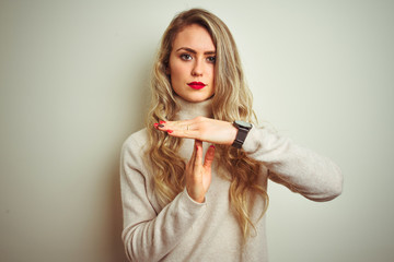 Beautiful woman wearing winter turtleneck sweater over isolated white background Doing time out gesture with hands, frustrated and serious face