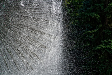 Fountain in the sun backlight. The fountains gushing sparkling water from pipe in park