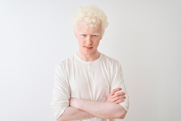 Young albino blond man wearing casual t-shirt standing over isolated white background skeptic and nervous, disapproving expression on face with crossed arms. Negative person. - obrazy, fototapety, plakaty