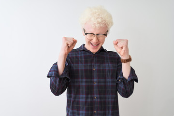 Young albino blond man wearing casual shirt and glasses over isolated white background excited for...