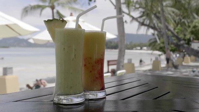 Tropical drinks sit on a bar waiting to be picked up.