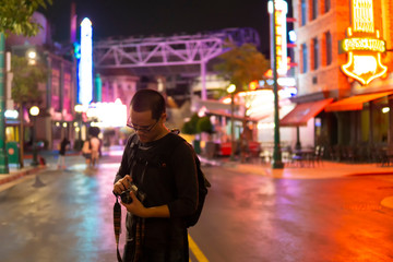 Obraz premium Photographer check old camera in city and Neon lights at the night