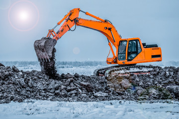 Excavator is loading excavation to the truck. Excavators hydraulic are heavy construction equipment consisting of a boom, dipper or stick , bucket and cab on a rotating platform.