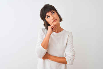 Fototapeta premium Young beautiful woman wearing casual t-shirt standing over isolated white background with hand on chin thinking about question, pensive expression. Smiling with thoughtful face. Doubt concept.