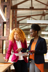Two interior designers using laptop while contacting clients
