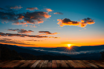 Fototapeta na wymiar Wood table with beautiful foggy winter sunrise in mountains background.