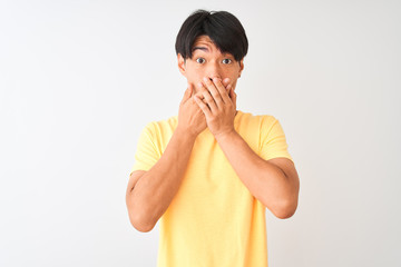 Chinese man wearing yellow casual t-shirt standing over isolated white background shocked covering mouth with hands for mistake. Secret concept.