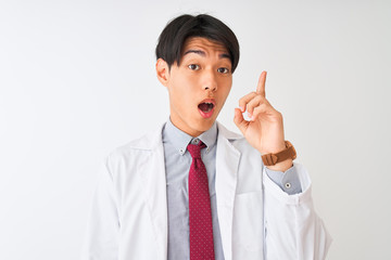Chinese scientist man wearing tie and coat standing over isolated white background pointing finger up with successful idea. Exited and happy. Number one.